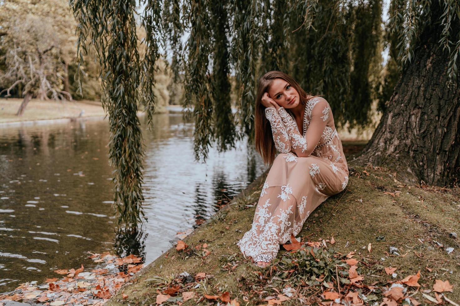 femme posant sous un arbre près de l & # 39; eau photo