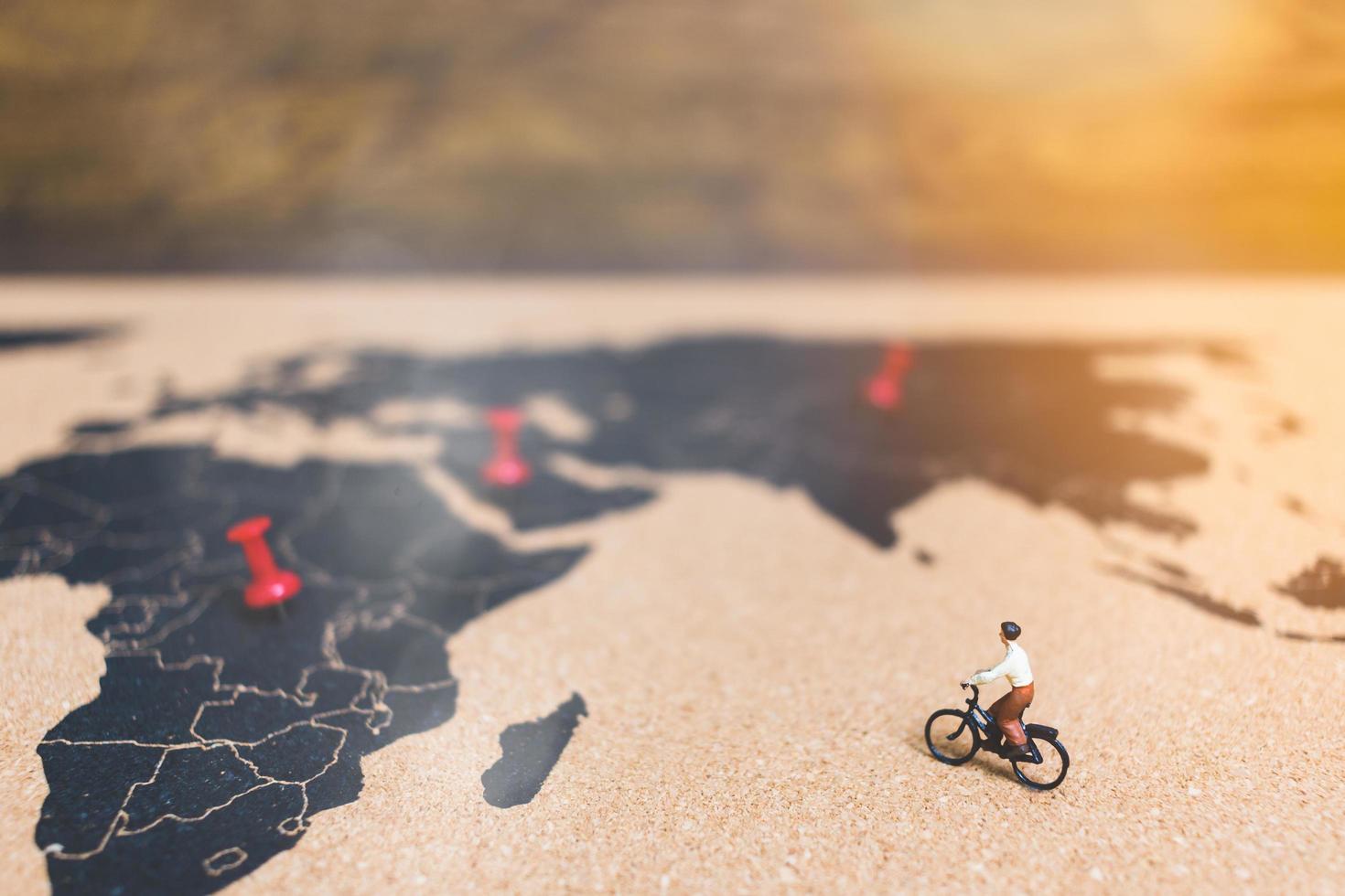 voyageurs miniatures à bicyclette sur une carte du monde, voyageant et explorant le concept du monde photo