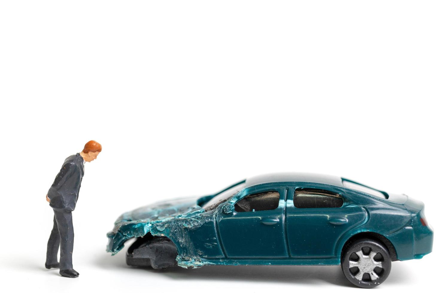 Personne miniature sur les lieux d'un accident de voiture, accident de voiture sur fond blanc, conduire en toute sécurité concept photo