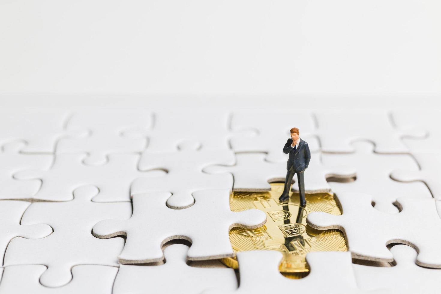 homme d & # 39; affaires miniature debout sur un puzzle blanc, concept d & # 39; entreprise photo