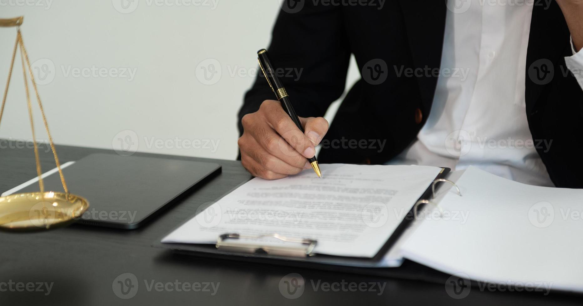 marteau de juge avec balance de justice, affaires et avocat ou conseiller consultant et discutant des documents contractuels avec ordinateur portable et tablette au cabinet d'avocats au bureau. photo