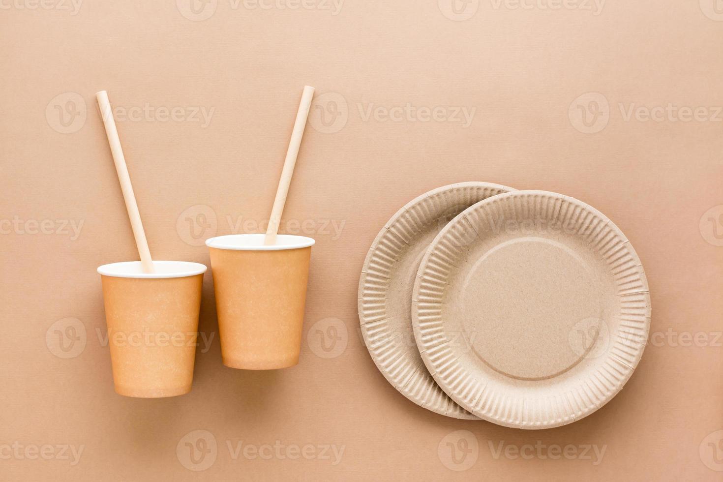 papier carton tasses, en buvant pailles et assiettes sur une beige Contexte. éco amical et zéro déchets concept. Haut voir. photo