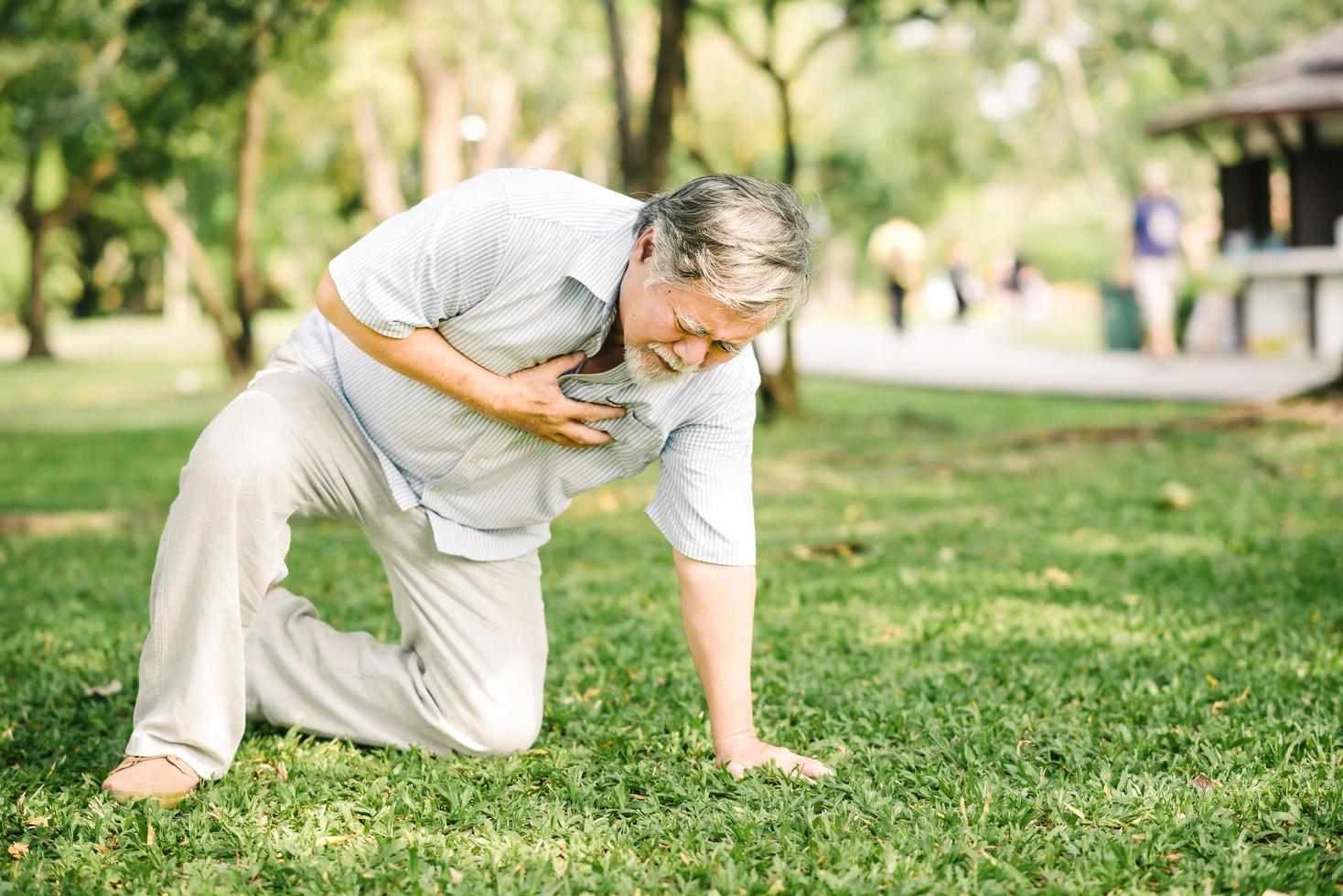 Senior man ressentir de la douleur souffrant d'une crise cardiaque en plein air photo