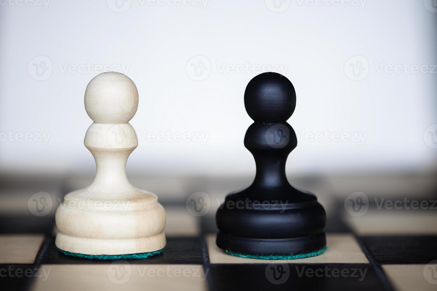 pièces d'échecs - deux adversaires tout aussi puissants se faisant face photo