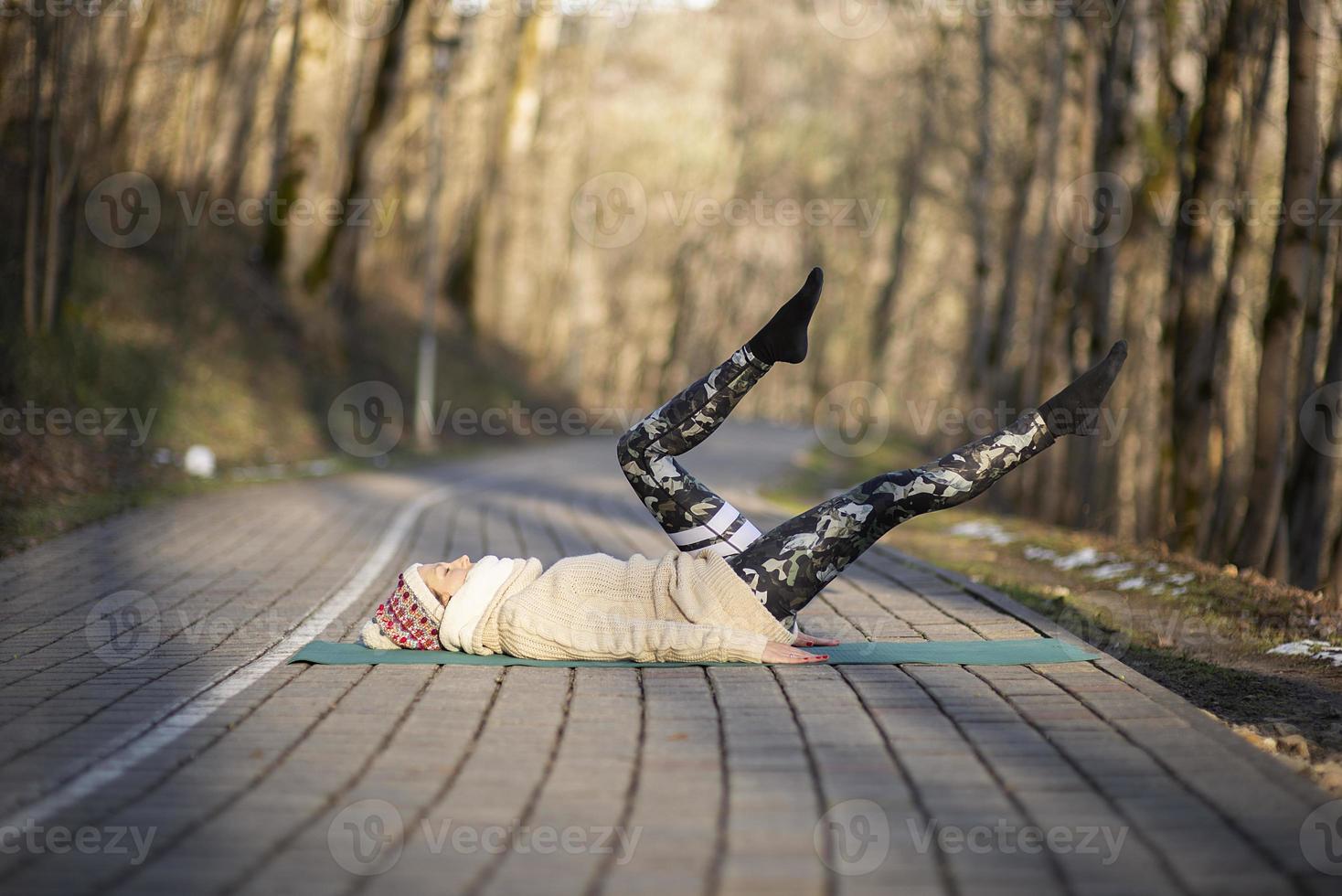 Une jeune femme athlétique effectue des exercices de yoga et de méditation à l'extérieur photo