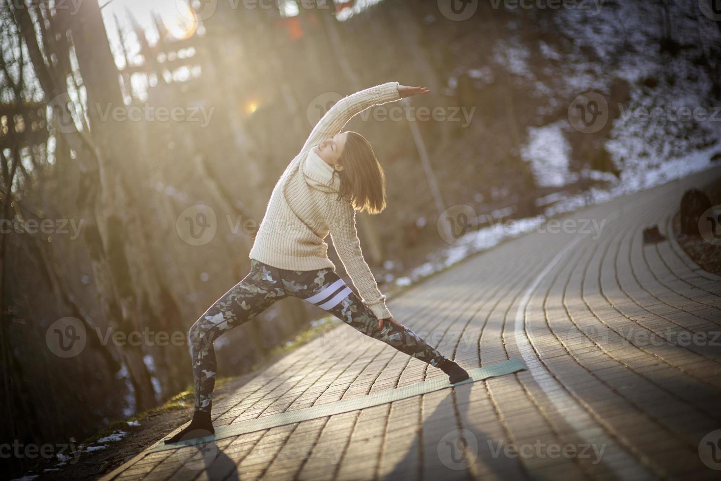 Une jeune femme athlétique effectue des exercices de yoga et de méditation à l'extérieur photo