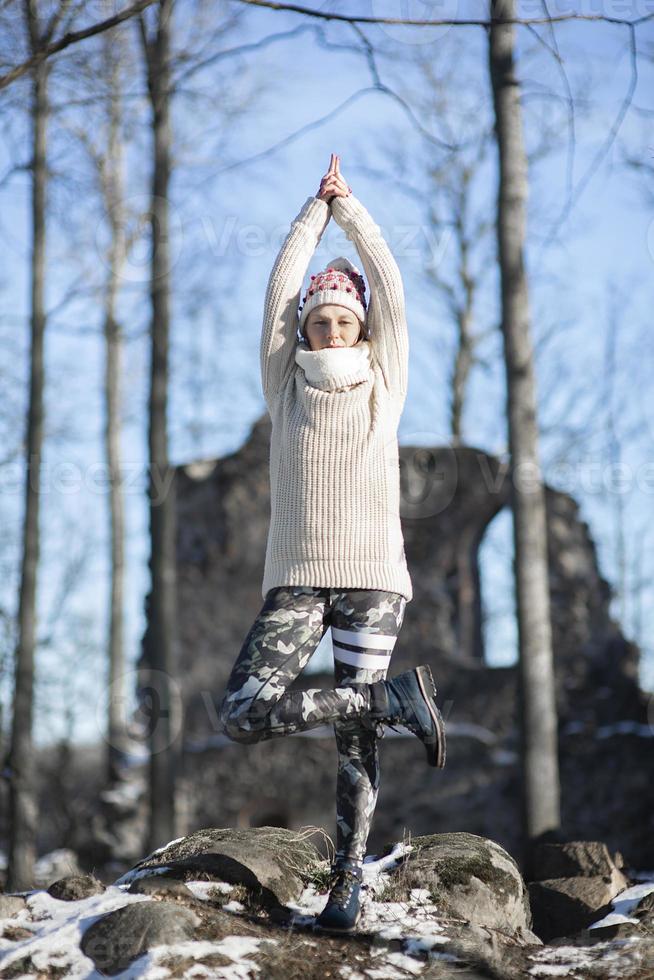 Une jeune femme athlétique effectue des exercices de yoga et de méditation à l'extérieur photo