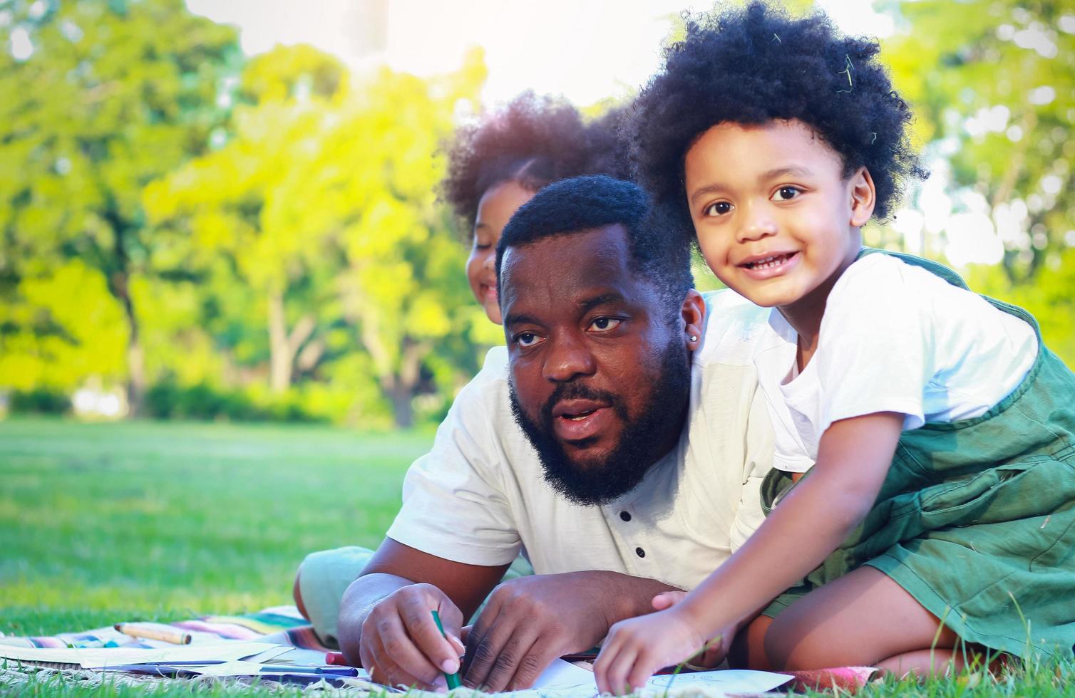 famille heureuse sur une couverture dans un parc photo