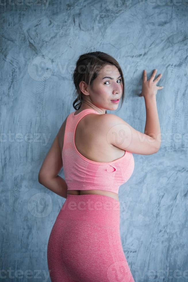 gros plan belle fille sportive asiatique sur le mur de la salle de sport, la thaïlande aime la santé, le concept d'entraînement de femme mince photo