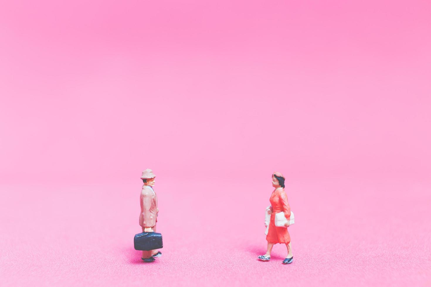 Couple miniature de voyageurs sur fond rose photo