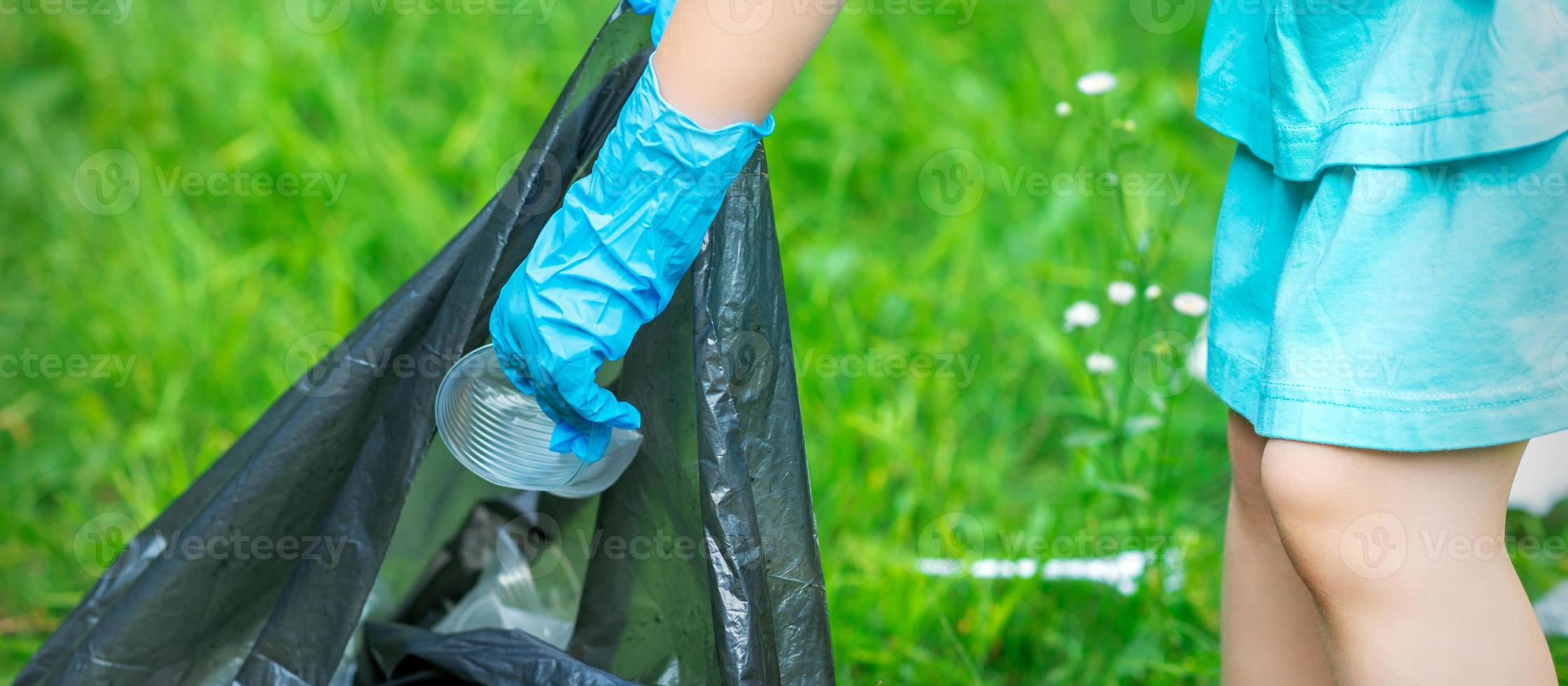 enfant met Plastique dans des ordures sac photo