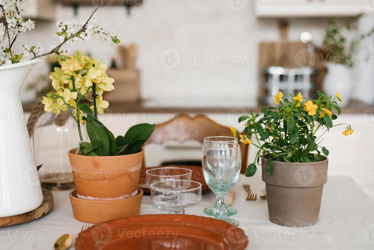 printemps décor de une confortable maison. fleurs dans argile marmites. portion Pâques petit déjeuner ou le déjeuner sur le table dans le cuisine photo