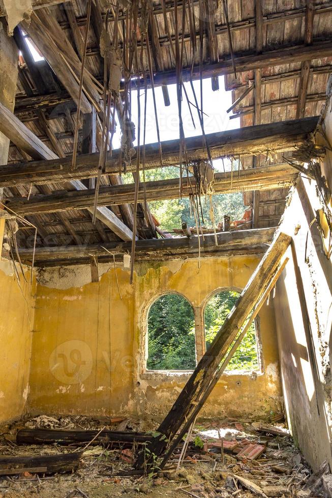 le abandonné intérieur de un vieux maison avec une cassé toit photo