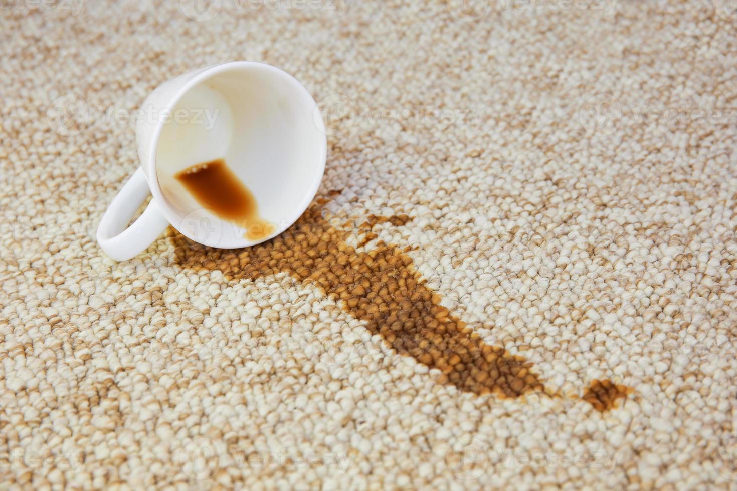 tasse de café est tombée sur tapis. tache est sur sol. photo