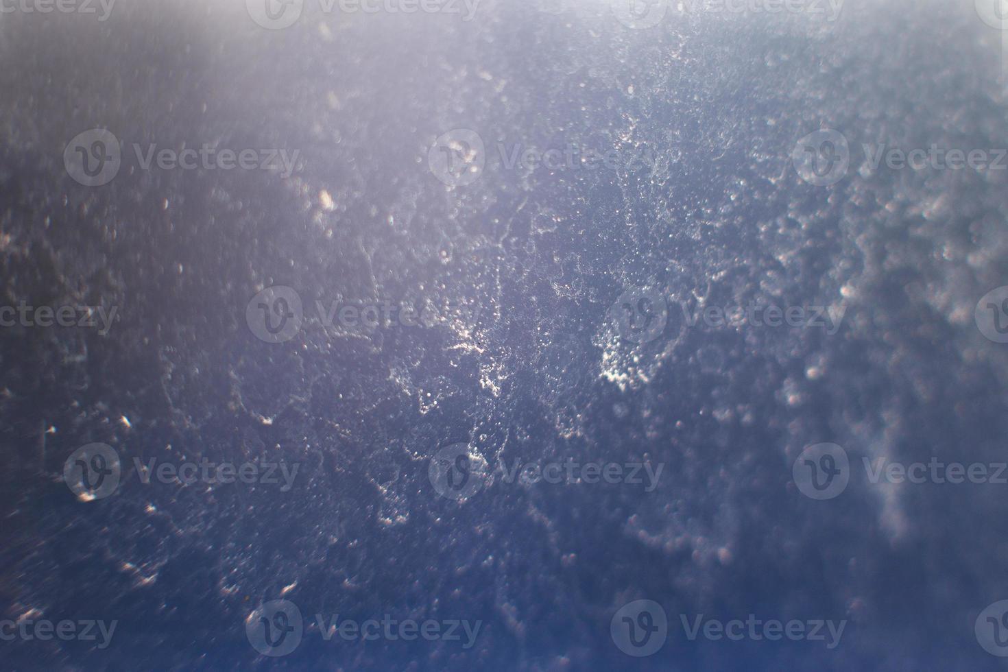 bleu abstrait Contexte. neige modèle sur le verre de gel. poussière sur le fenêtre photo