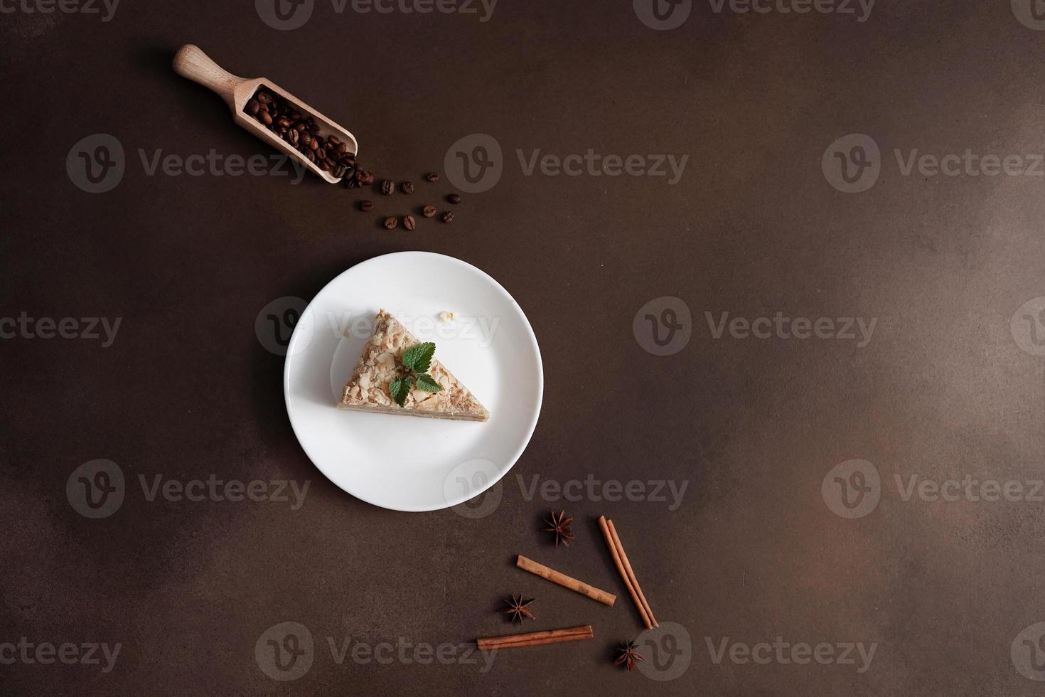Haut vue de Frais délicieux gâteau napoléon avec crème sur une marron Contexte. une cannelle bâton, Badyan, café des haricots sur une marron Contexte. copie espace photo