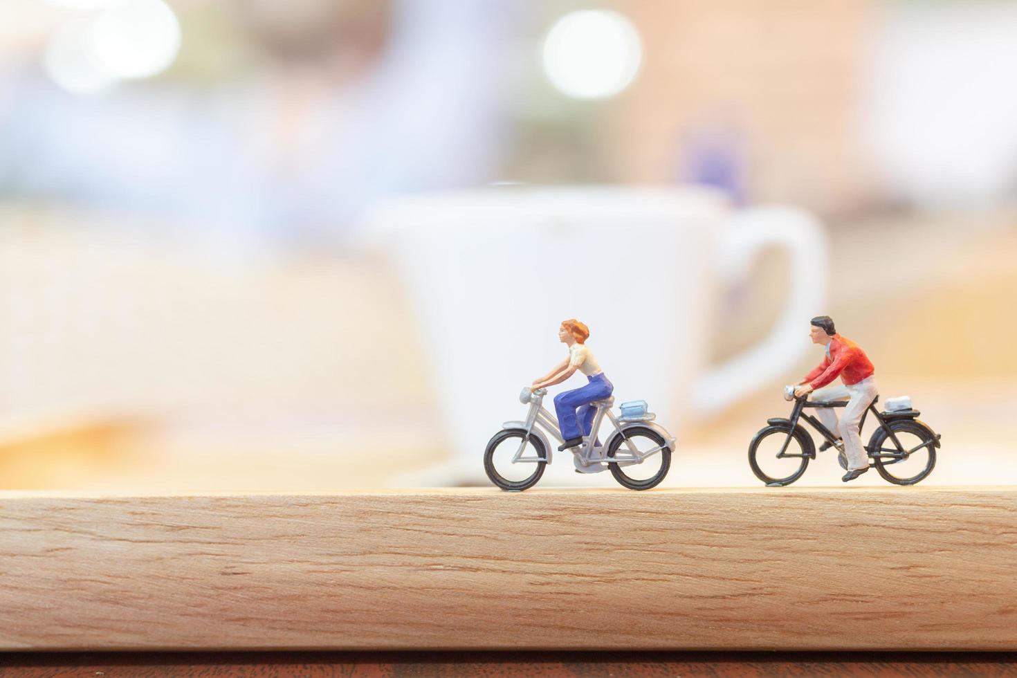 personnes miniatures à vélo sur un pont en bois, concept de soins de santé photo
