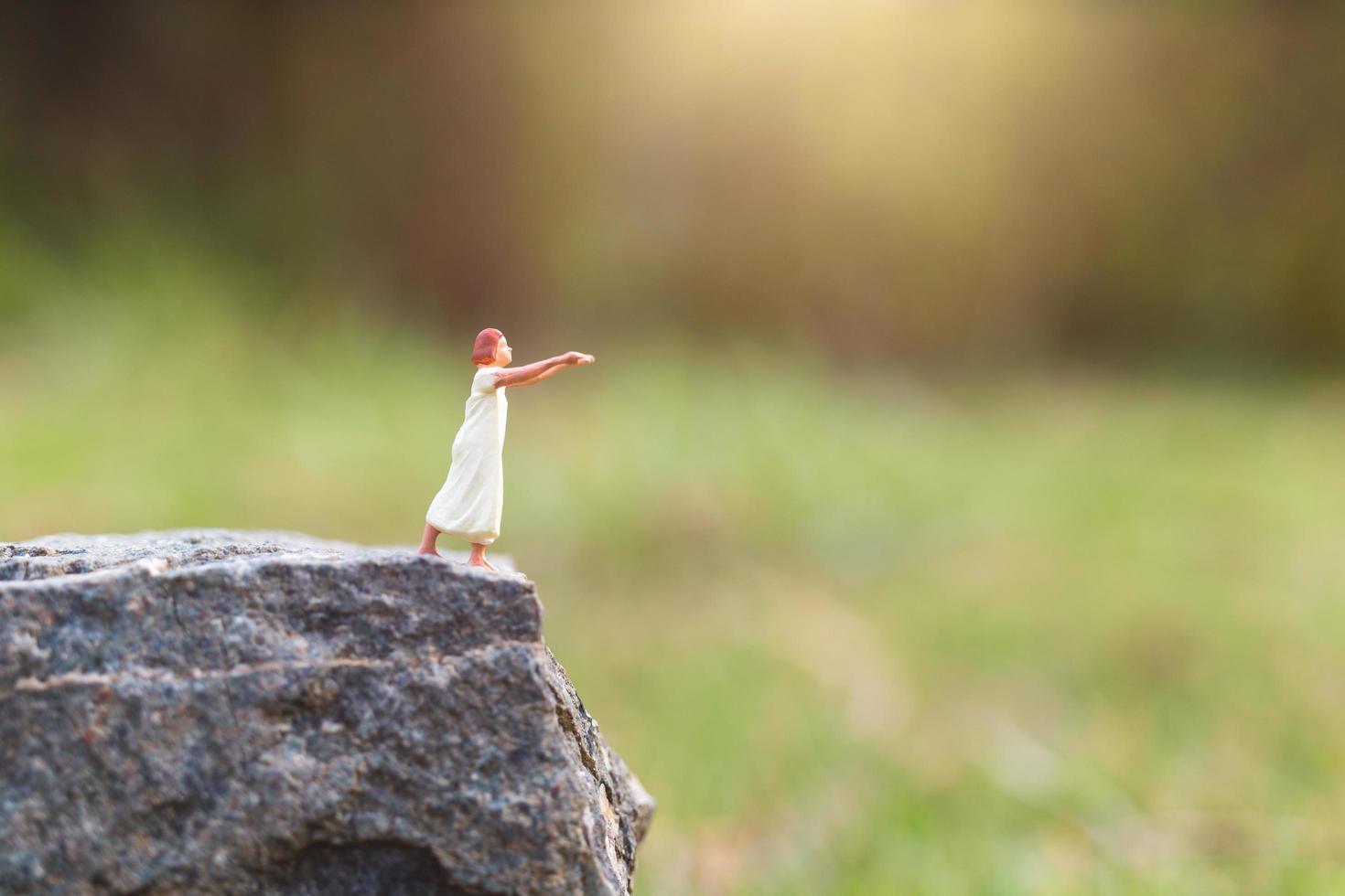 Femme endormie miniature souffrant de somnambulisme sur une falaise rocheuse avec un fond de nature photo