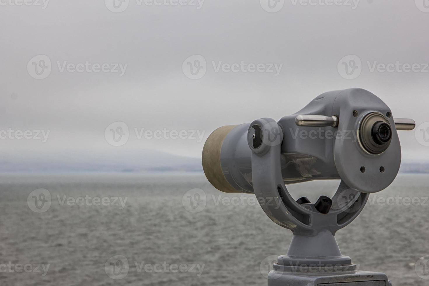 pièce de monnaie opéré télescope téléspectateur suivant à le riverain promenade à la recherche en dehors à le baie et ville. photo