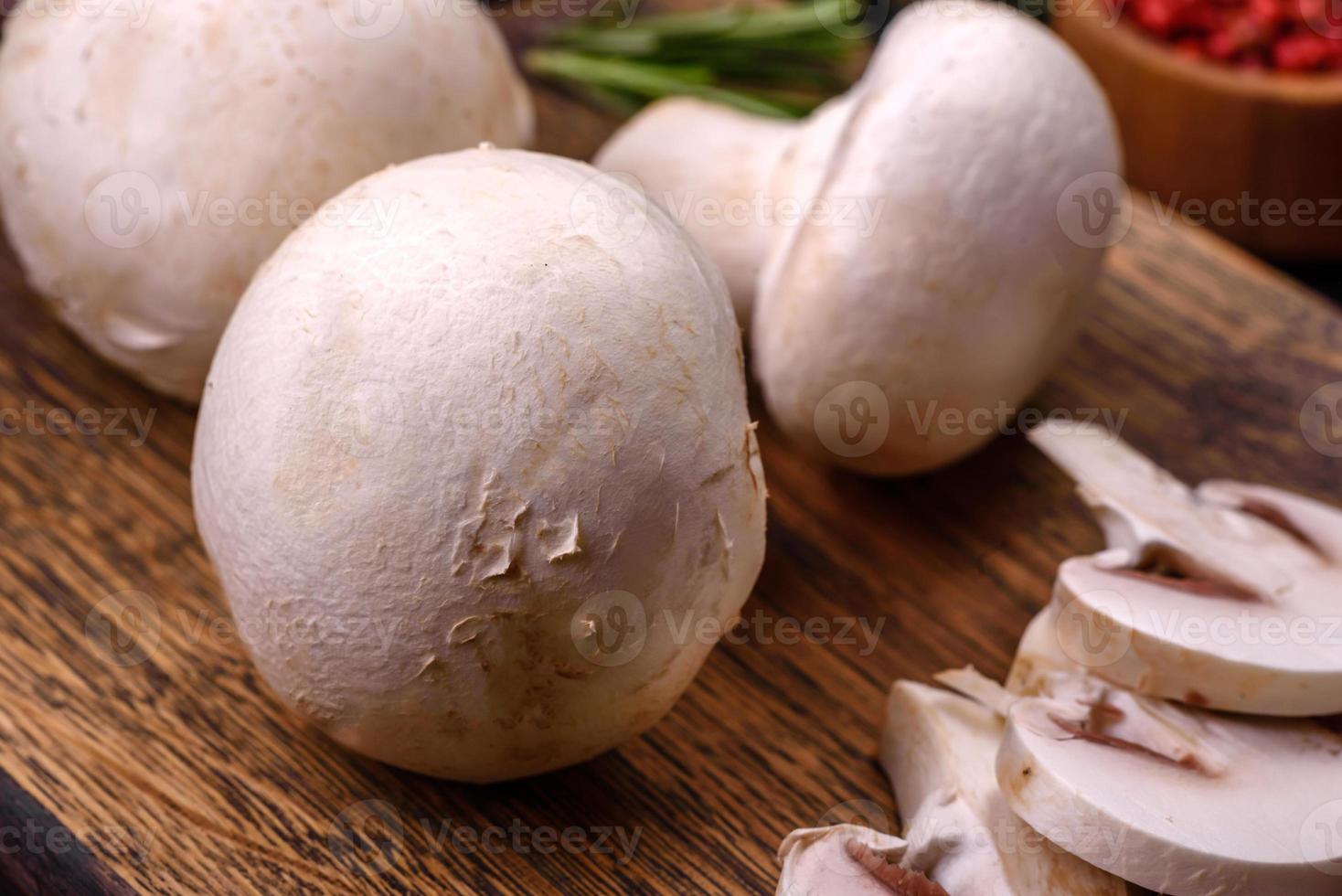 Frais brut champignon champignons sur une en bois Coupe planche avec épices photo