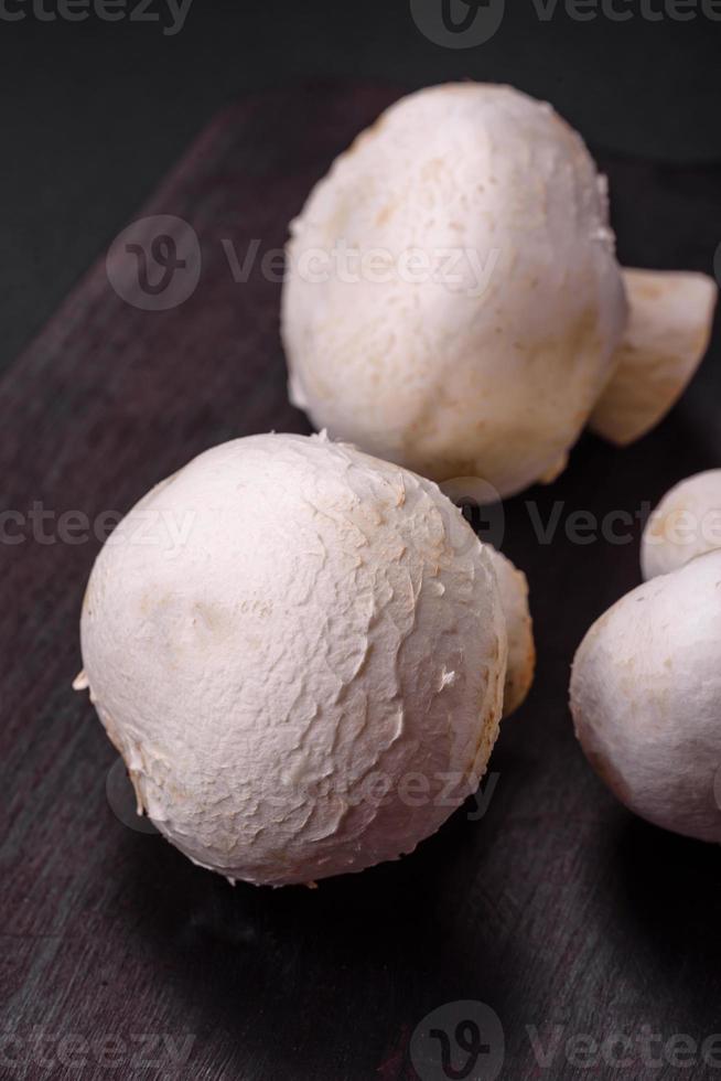 Frais brut champignon champignons sur une en bois Coupe planche avec épices photo