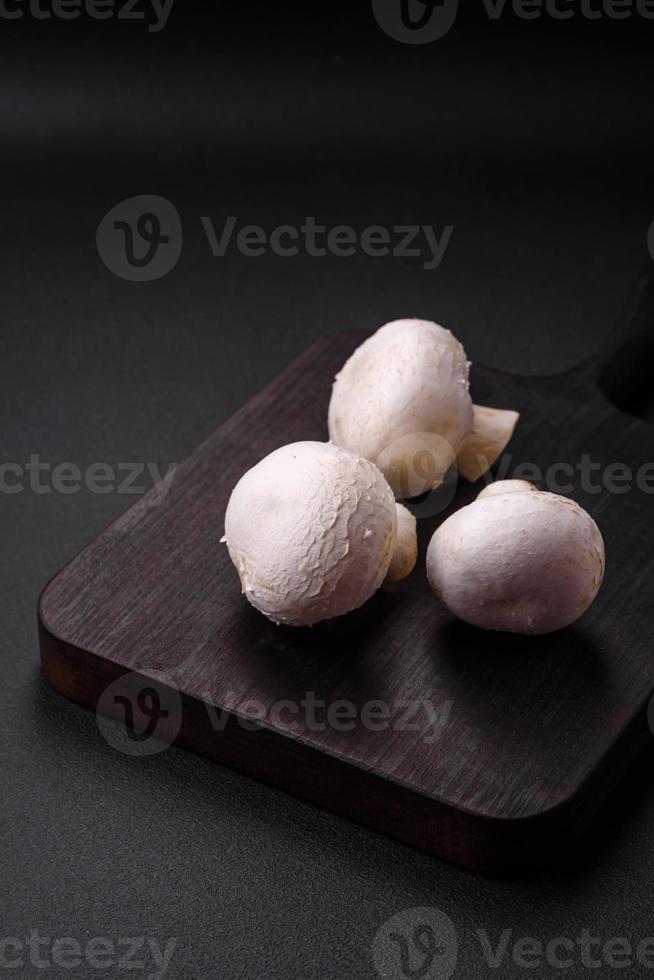 Frais brut champignon champignons sur une en bois Coupe planche avec épices photo