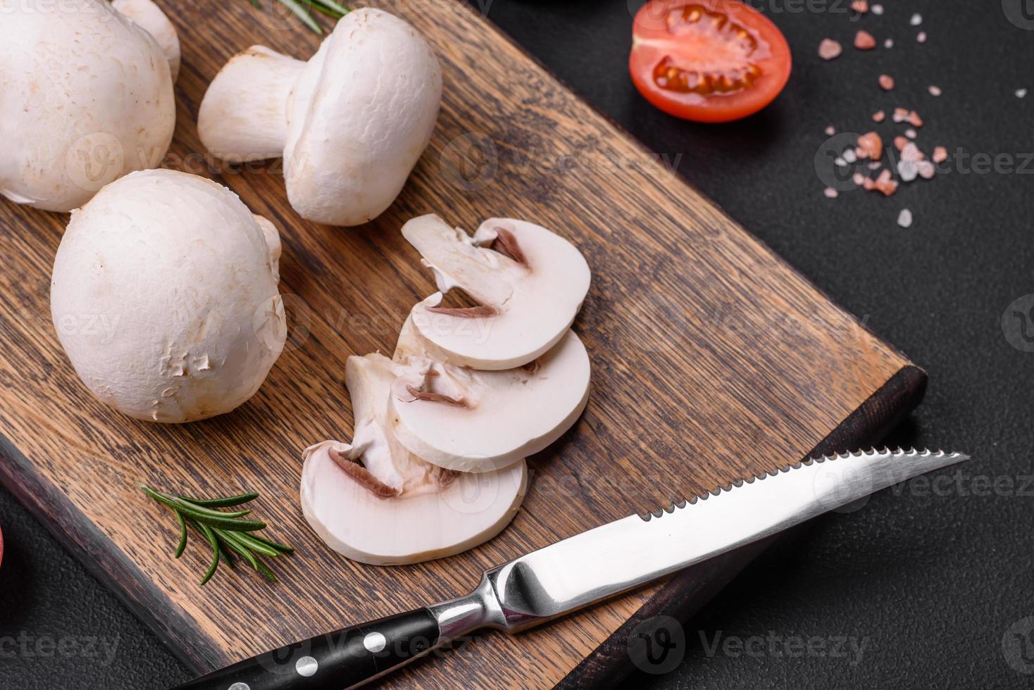 Frais brut champignon champignons sur une en bois Coupe planche avec épices photo