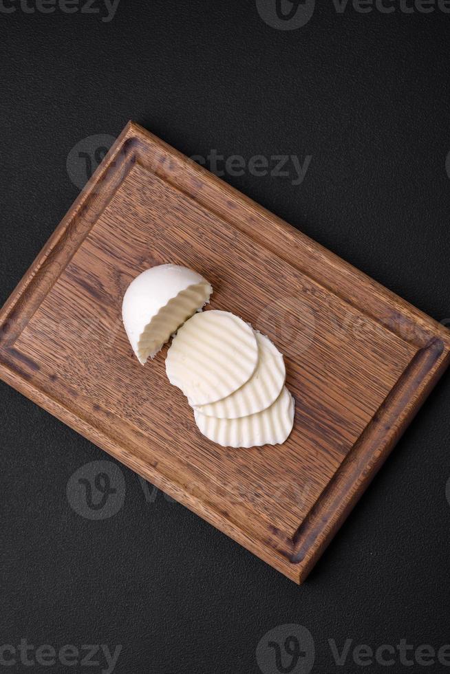délicieux Frais mozzarella Couper dans tranches sur une en bois Coupe planche photo