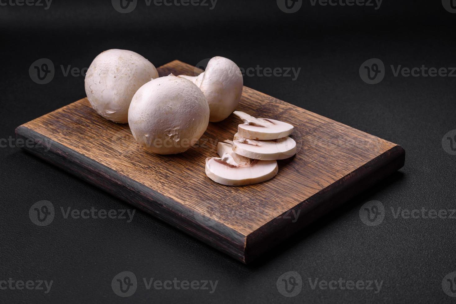 Frais brut champignon champignons sur une en bois Coupe planche avec épices photo