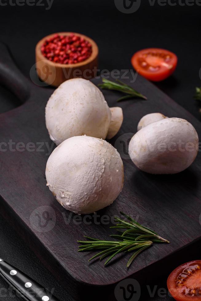 Frais brut champignon champignons sur une en bois Coupe planche avec épices photo