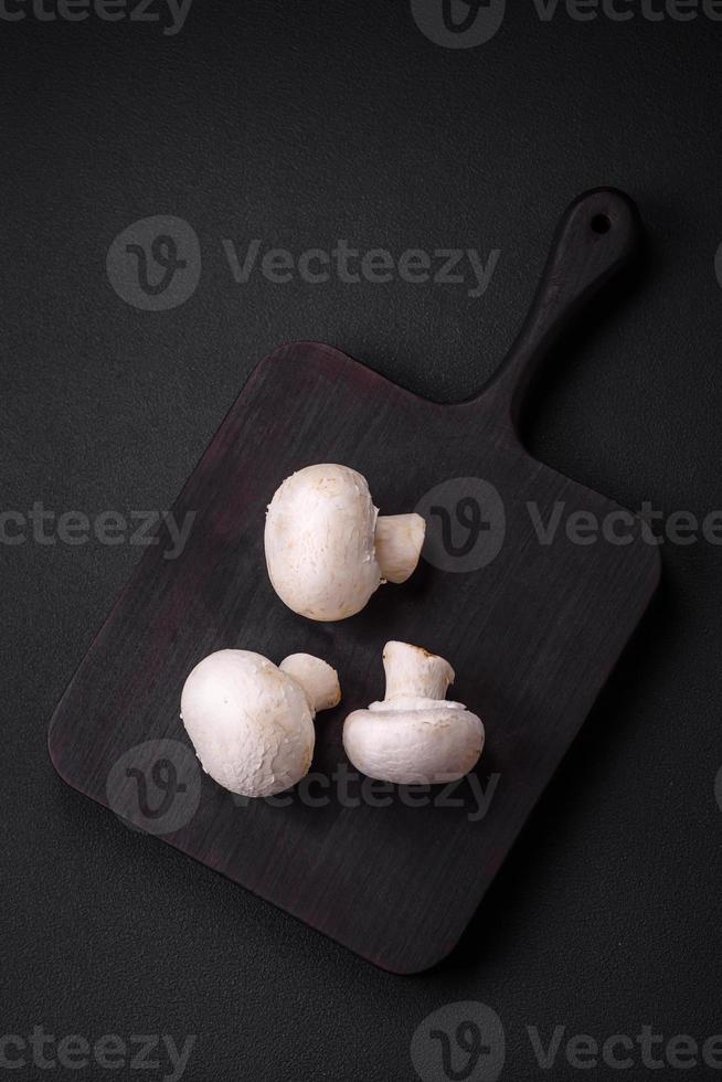 Frais brut champignon champignons sur une en bois Coupe planche avec épices photo