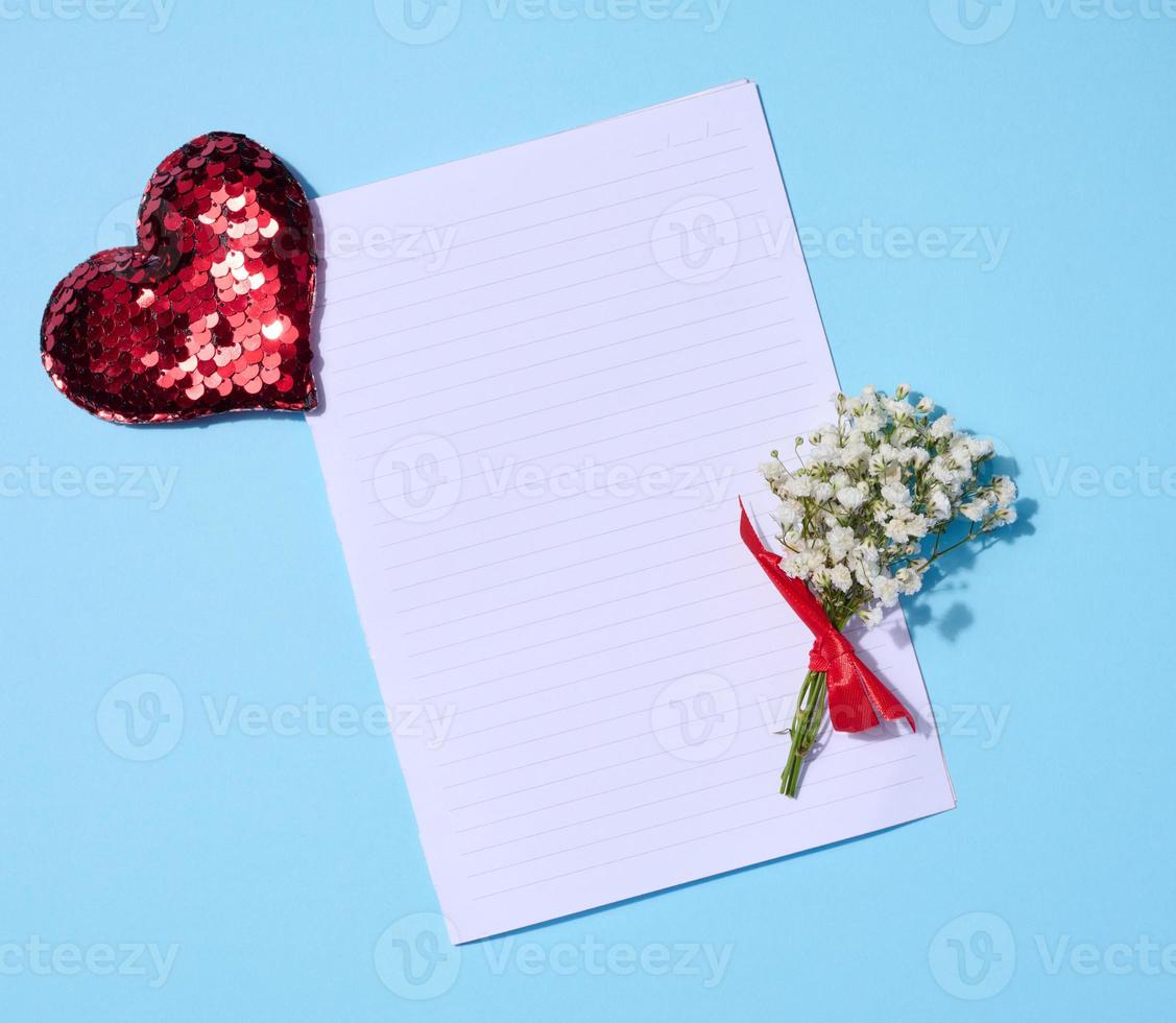 vide feuille de papier, gypsophile bouquet et rouge paillette cœur sur une bleu arrière-plan, Haut vue photo