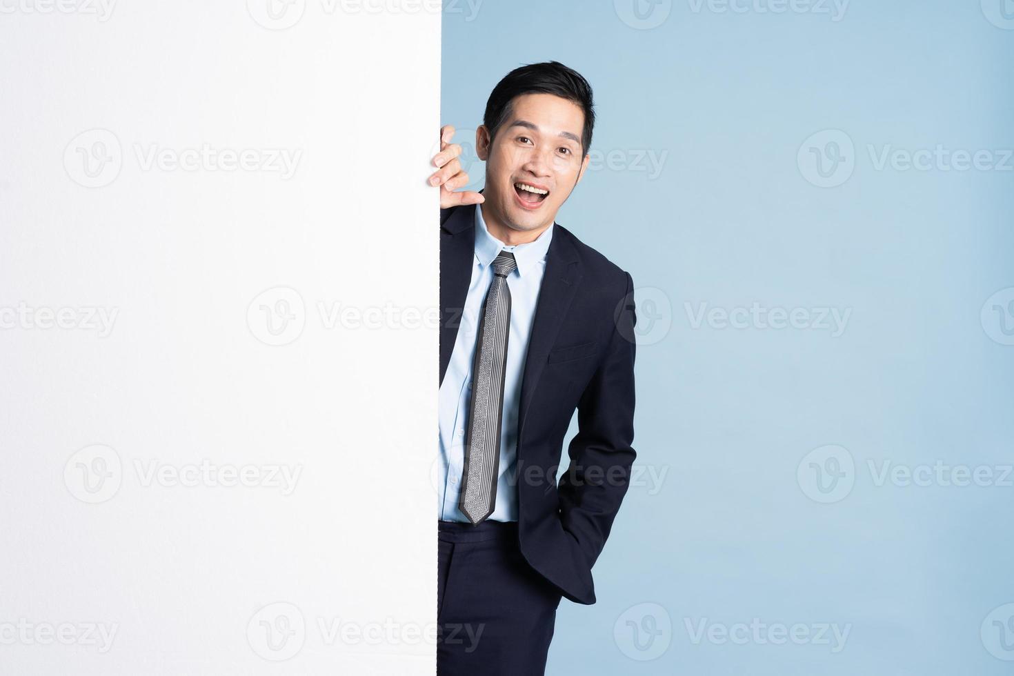 Portrait d'un homme d'affaires asiatique portant un costume sur fond bleu photo