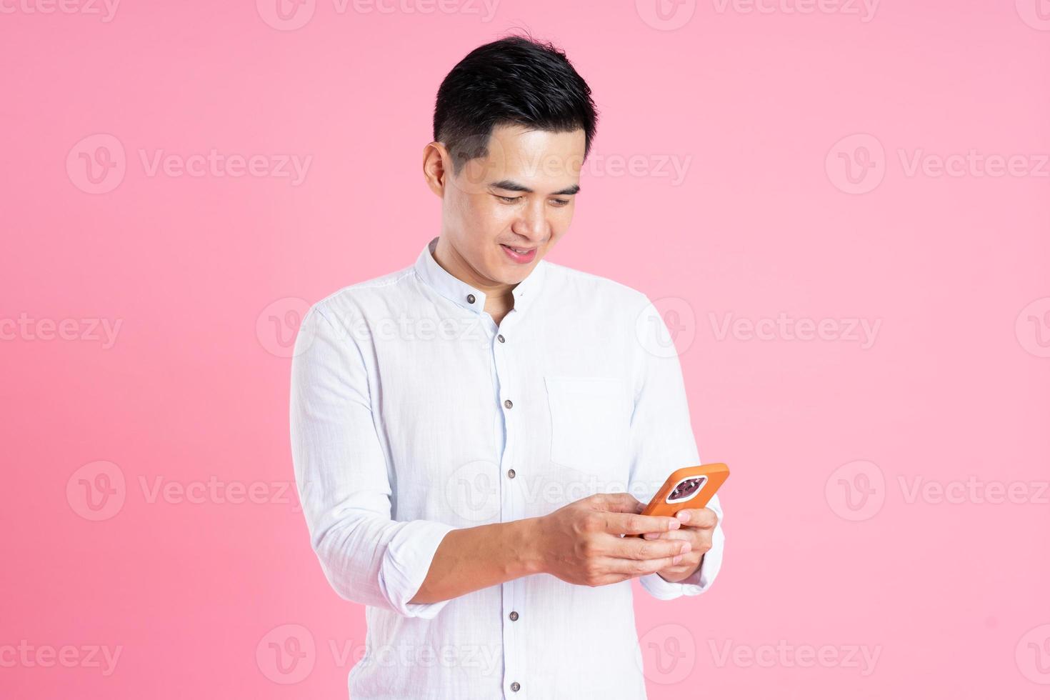 portrait d'homme asiatique posant sur fond rose photo