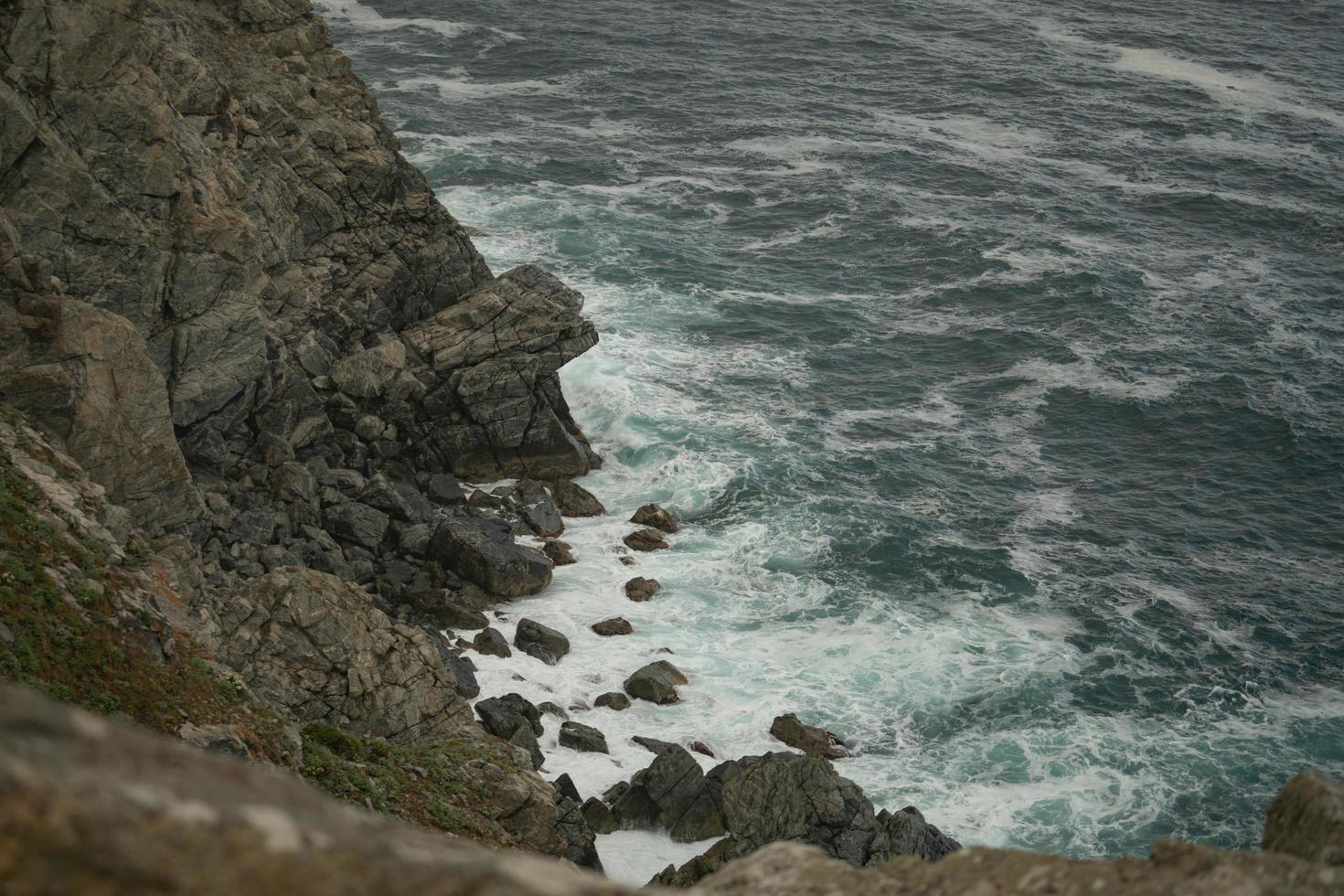 paysage marin avec des vagues se brisant sur les rochers photo