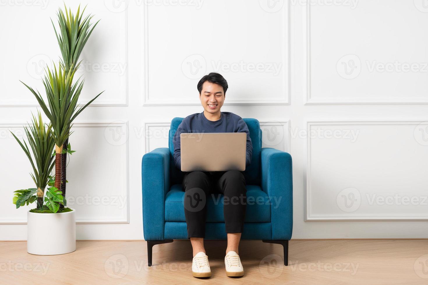 portrait de asiatique homme séance sur canapé à Accueil photo