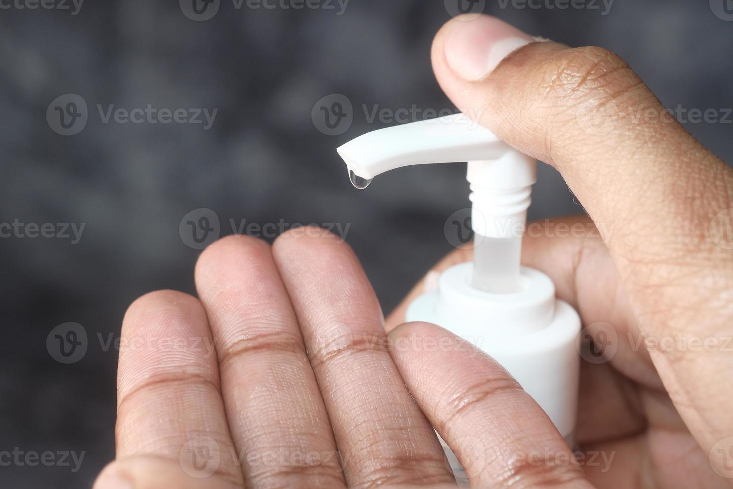 Coup de détail de la main de l'homme à l'aide d'un désinfectant photo