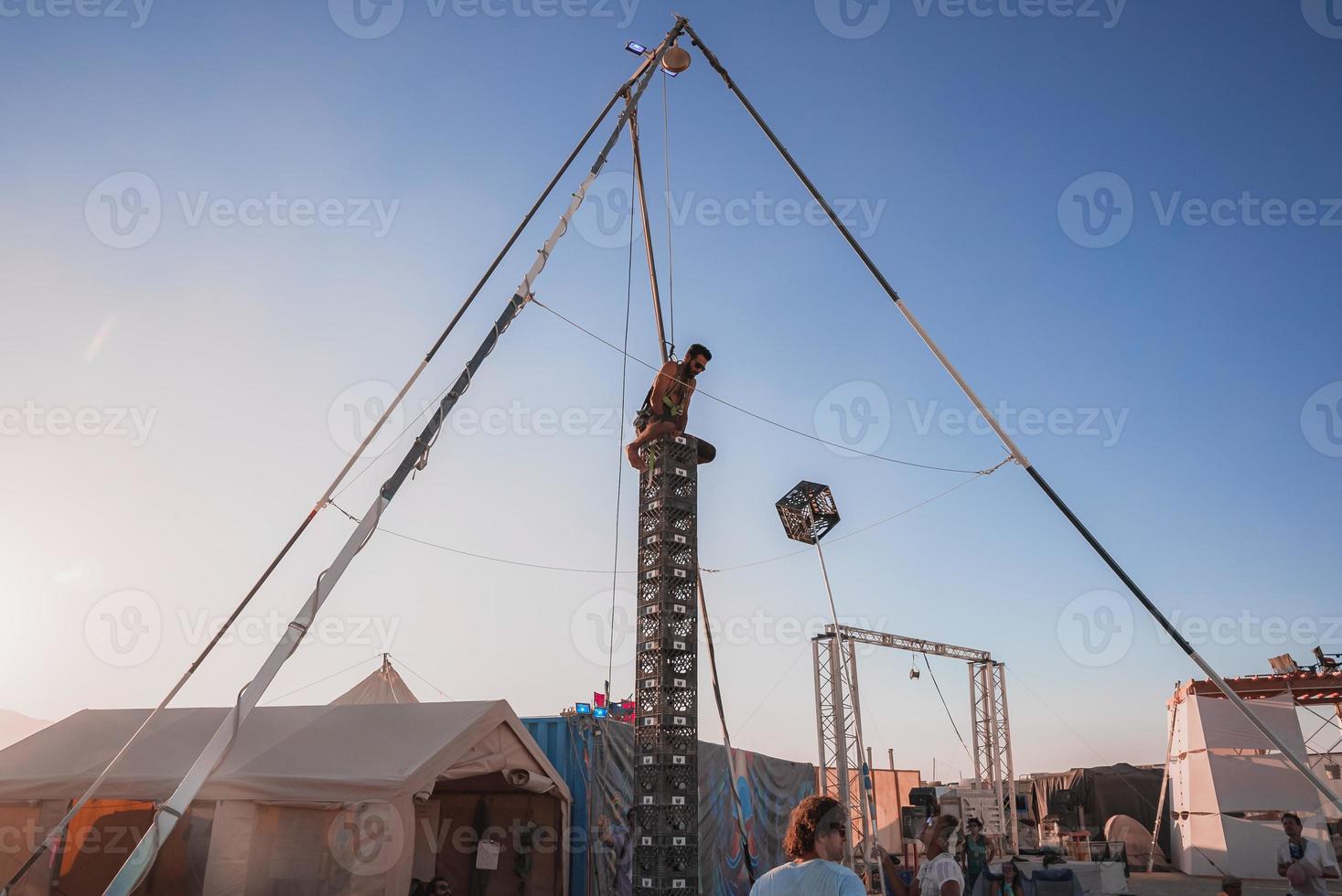 gens en marchant vers le coucher du soleil à une Festival dans le désert à le brûlant homme festival. photo