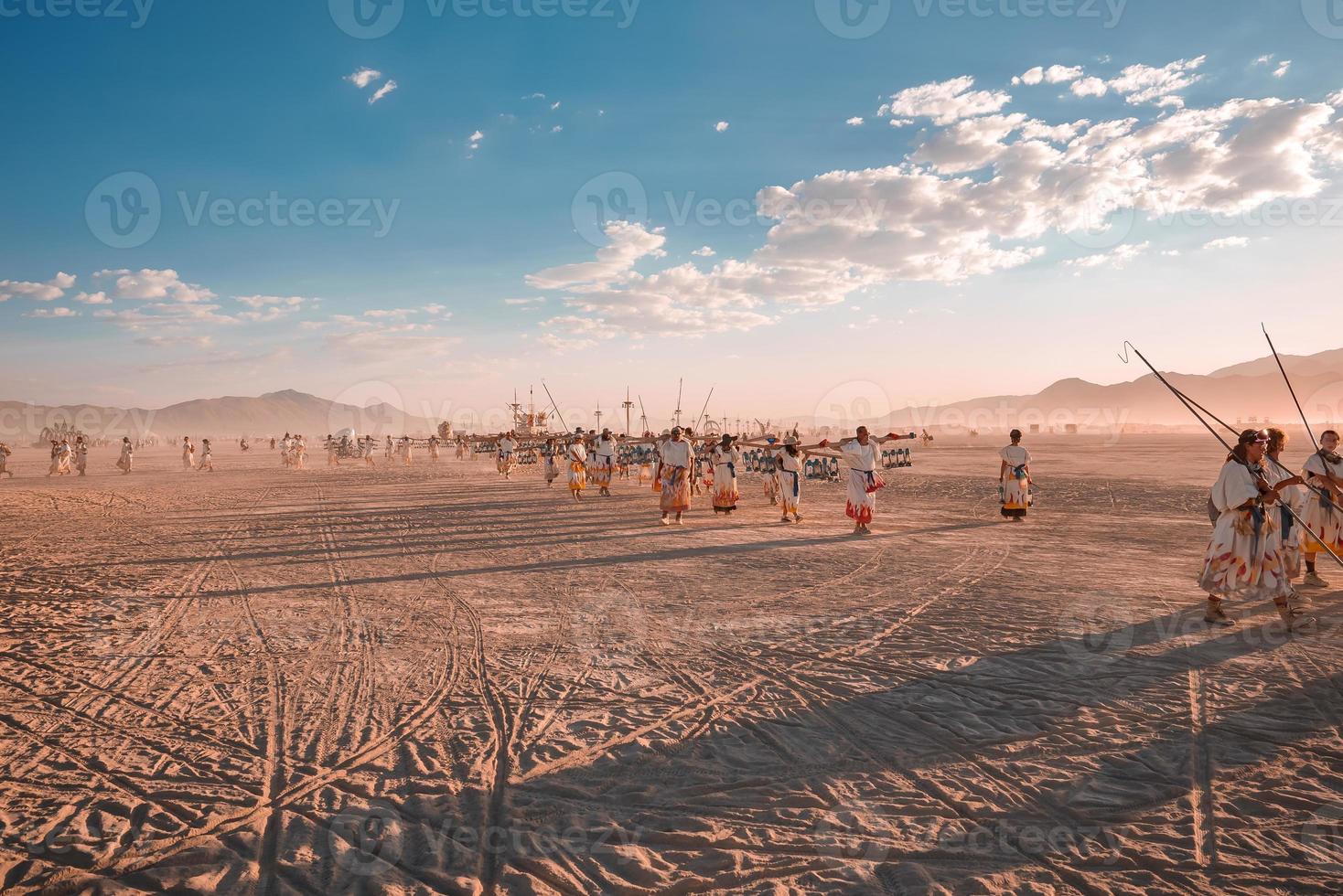 gens en marchant vers le coucher du soleil à une Festival dans le désert à le brûlant homme festival. photo