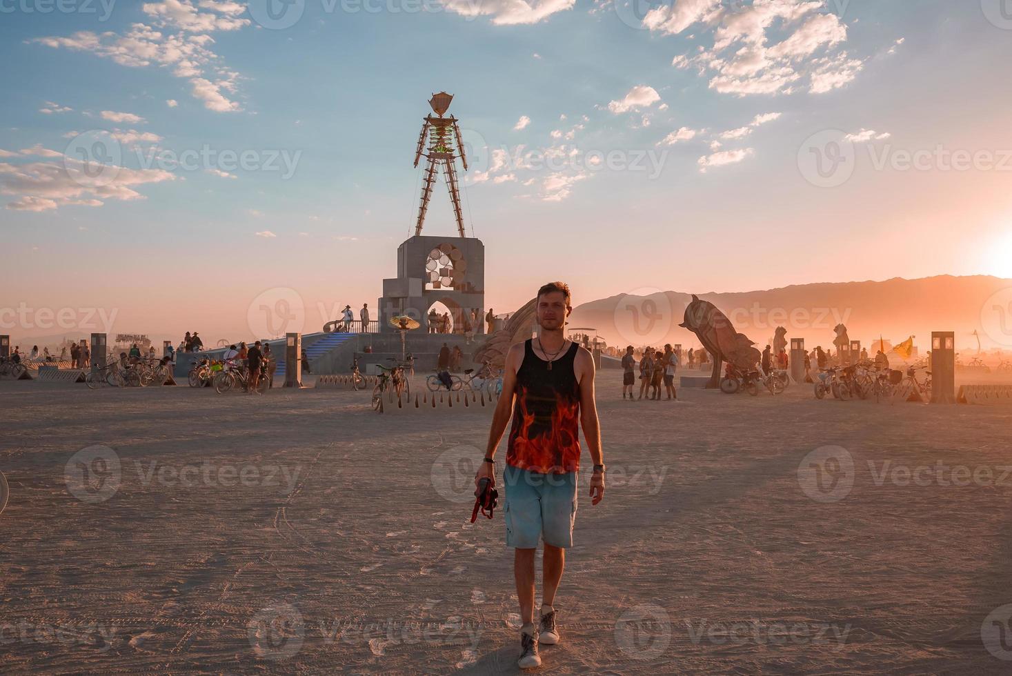 gens en marchant vers le coucher du soleil à une Festival dans le désert à le brûlant homme festival. photo