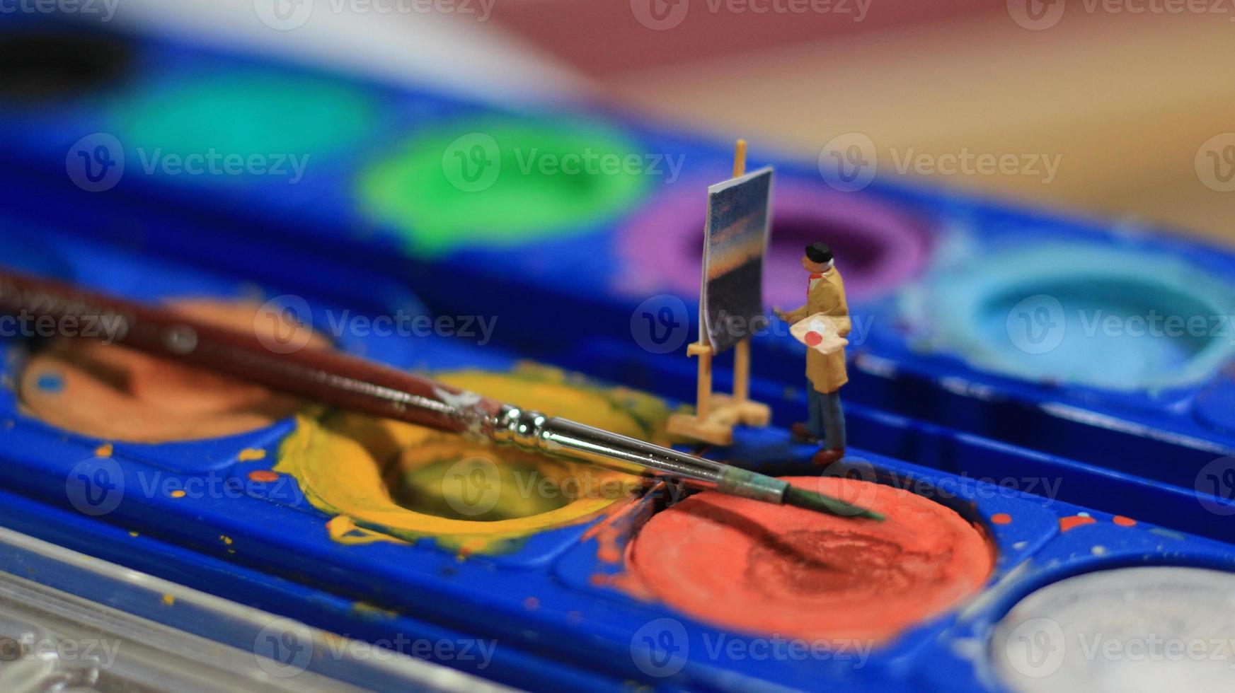 une miniature figure de une peintre La peinture une paysage sur aquarelles. artiste concept. photo