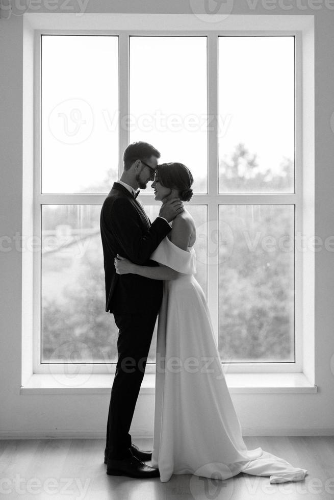 jeune marié dans une noir costume attacher et le la mariée dans une brillant studio photo