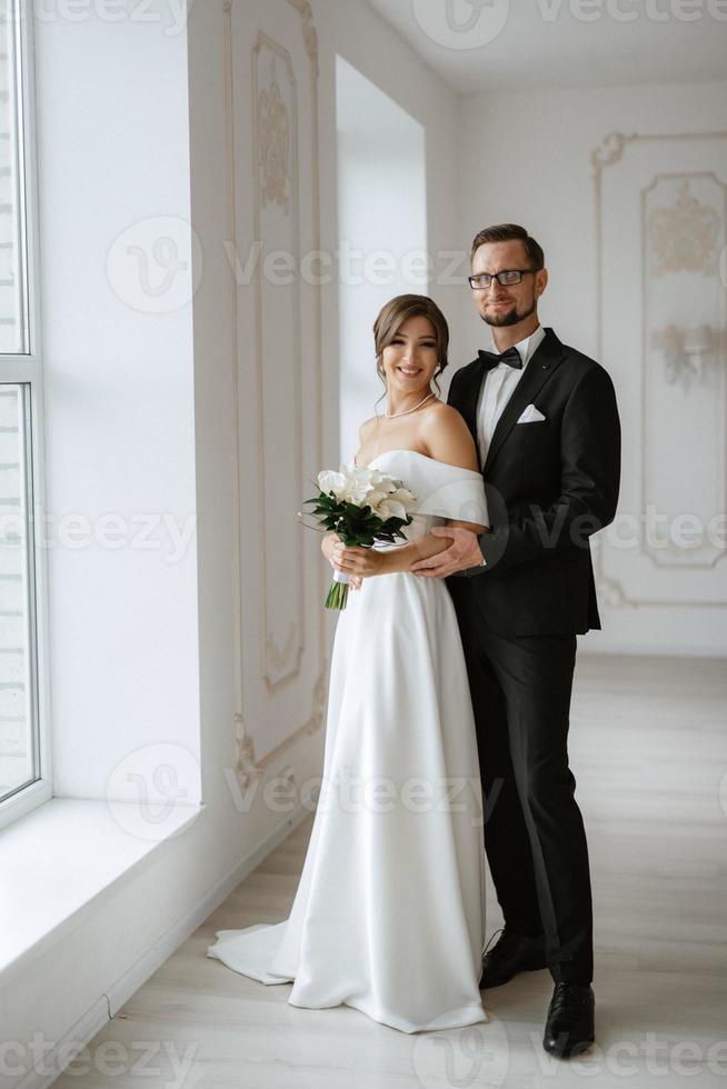 jeune marié dans une noir costume attacher et le la mariée dans une brillant studio photo