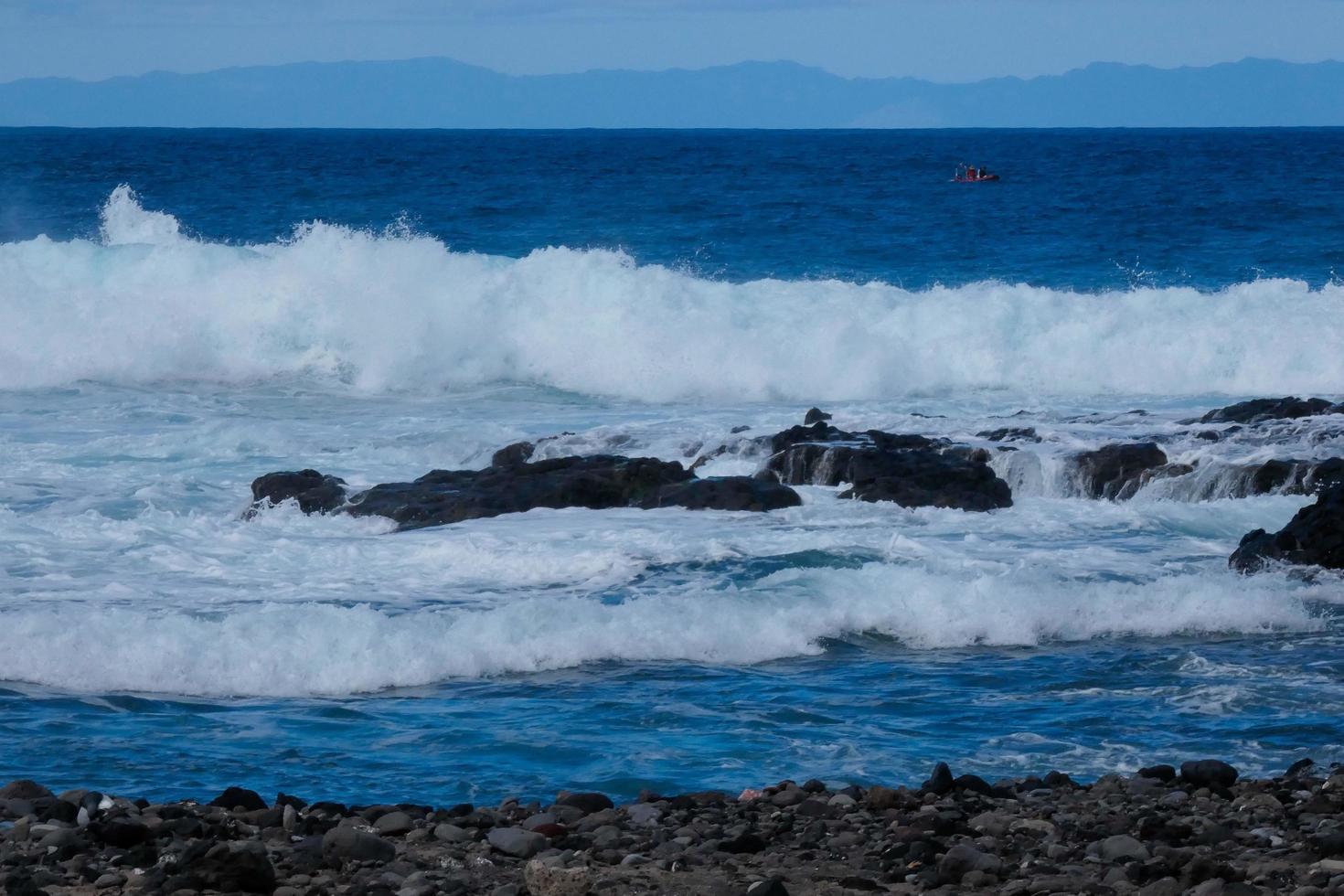 grand vagues s'écraser contre le rochers dans le océan photo