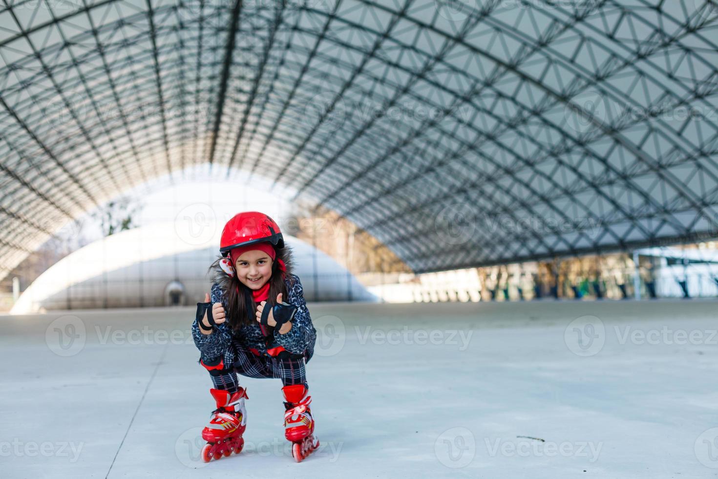 peu mignonne content fille patin à roues alignées dans une gros hangar photo