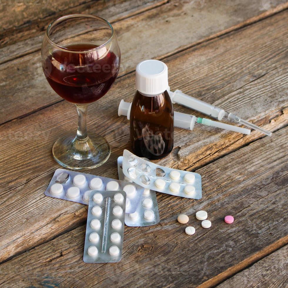 des médicaments et de l'alcool sur le vieux en bois Contexte. photo