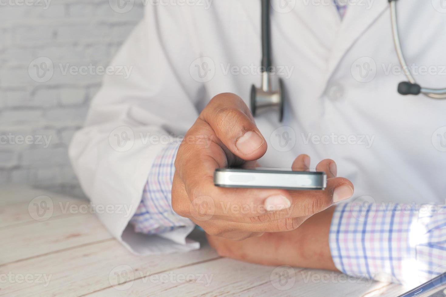 médecin en blouse blanche à l'aide d'un smartphone photo