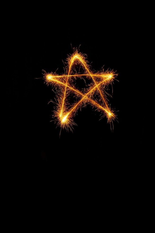 étoile fabriqué avec cierges magiques prêt pour votre les inscriptions sur noir Contexte photo
