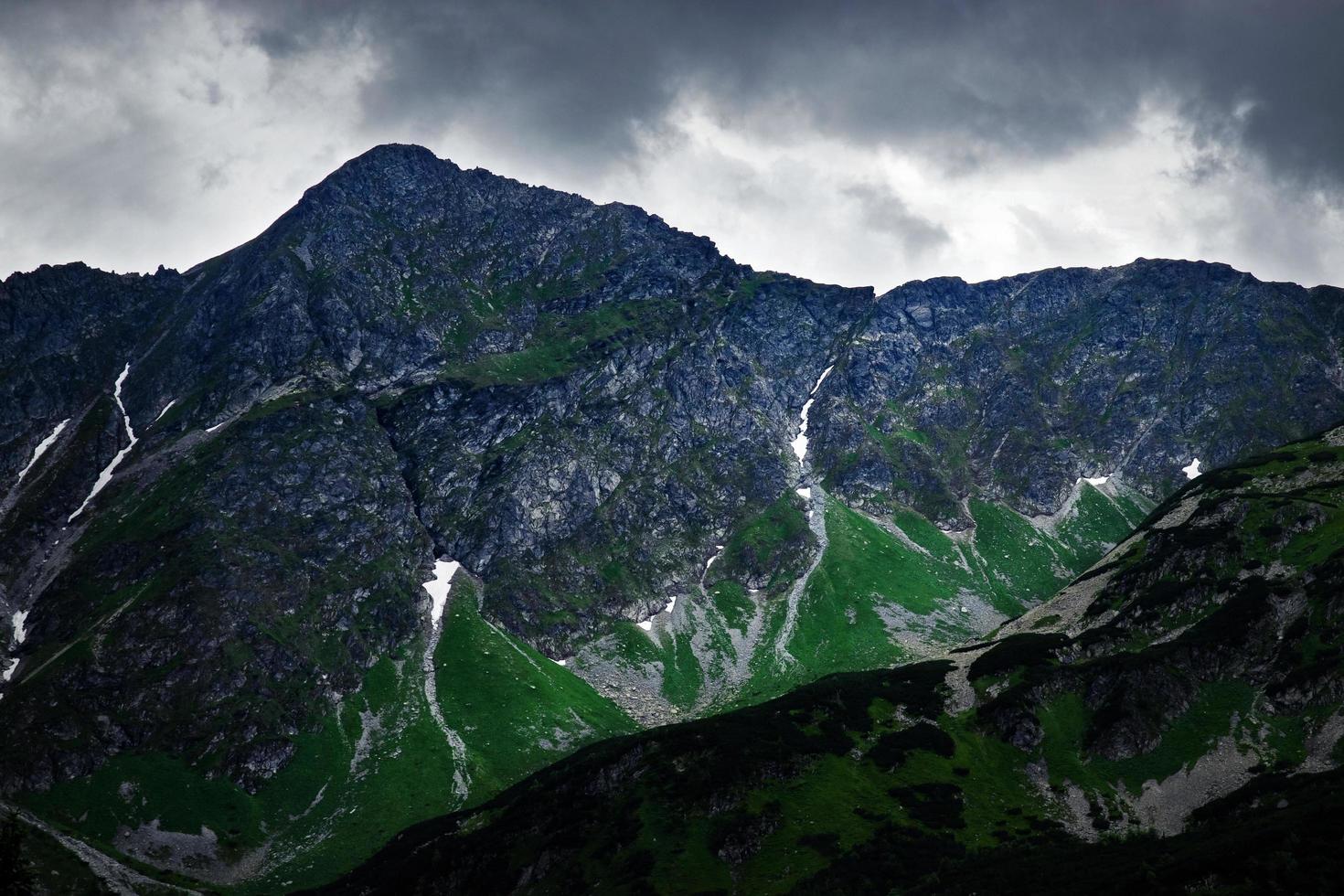 ciel sombre sur un pic rocheux dans les montagnes photo