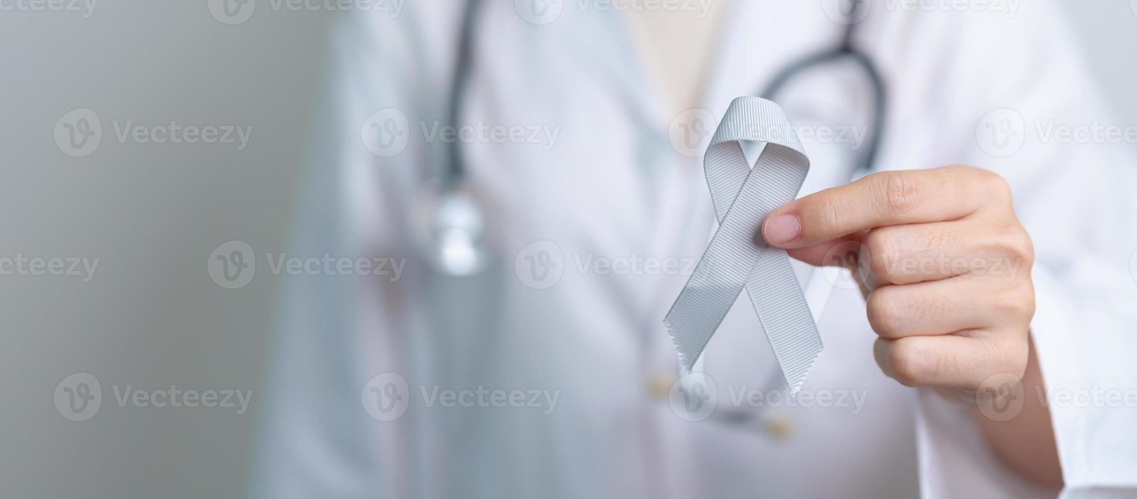 cerveau cancer conscience mai mois, médecin avec gris Couleur ruban pour justificatif la vie personnes. soins de santé et monde cancer journée concept photo